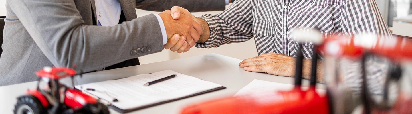 Tractor financing handshake at a bank